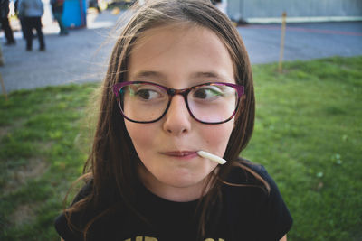 Close-up of girl wearing eyeglasses looking away outdoors