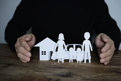 Close-up of man holding hands on table