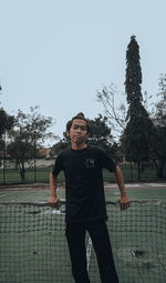 Portrait of young man standing against sky