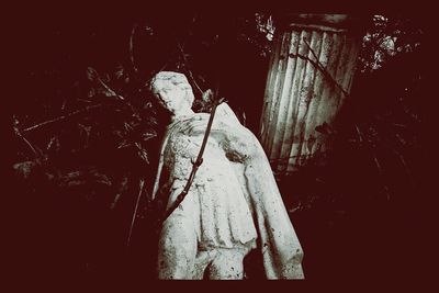 Woman standing with arms outstretched at night