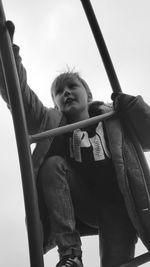 Portrait of boy on swing in playground