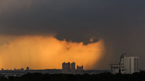 Silhouette cityscape against sky during sunset