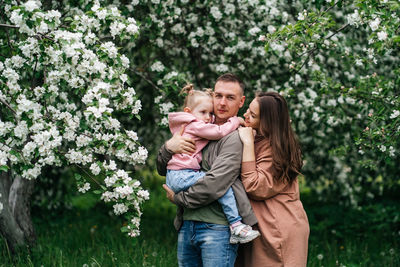 Family mom mom baby daughter in the garden blooming apple trees