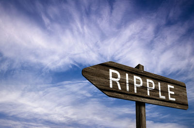 Low angle view of road sign against blue sky