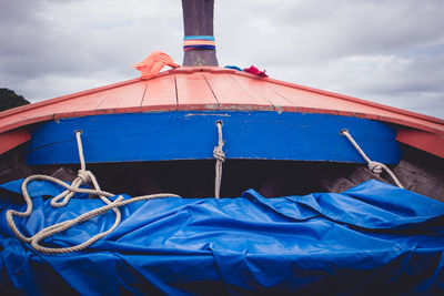 Tarpaulin on boat against cloudy sky