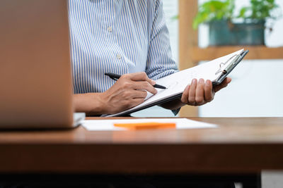 Low angle view of man using mobile phone on table