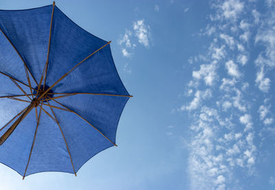 Low angle view of umbrella against blue sky