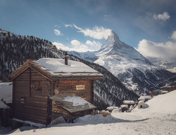 Houses on snowcapped mountain against sky