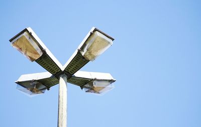 Low angle view of windmill against clear blue sky