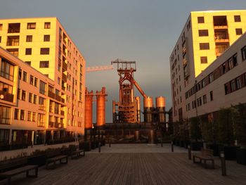 Road amidst buildings against sky