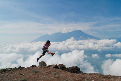 Side view of man on mountain against sky