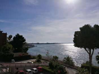 Scenic view of sea and trees against sky