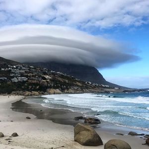 Scenic view of sea by snowcapped mountains against sky