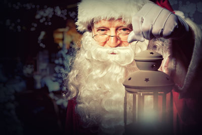 Close-up portrait of santa claus holding lantern