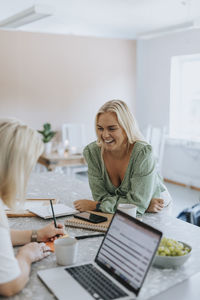 Smiling women talking in kitchen