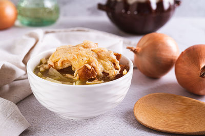 Homemade onion soup with croutons and cheese in a bowl on the table