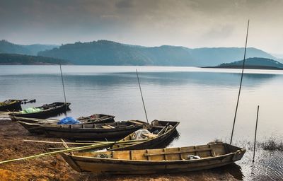 Boat moored in lake against sky