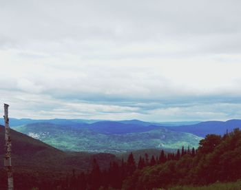 Scenic view of mountain range against cloudy sky