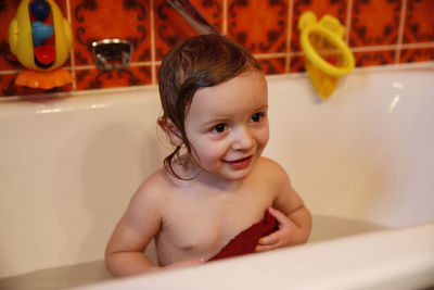 Happy girl in bathtub at home