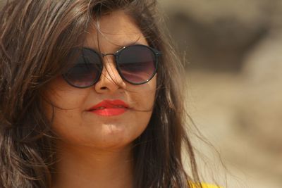 Close-up portrait of young woman wearing sunglasses