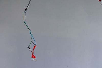 Low angle view of red bell hanging against sky