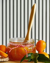 Close-up of orange fruits in glass jar on table