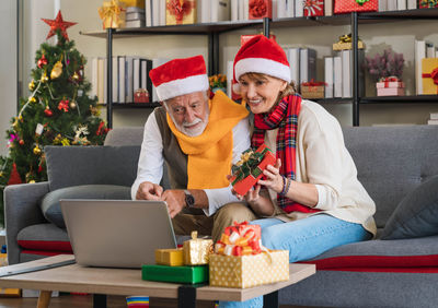 Portrait of man using laptop while sitting on sofa at home