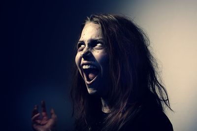 Spooky young woman against gray wall