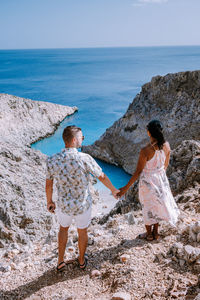 Rear view of couple looking at sea against sky