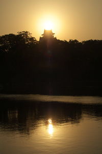 Sun shining over lake during sunset