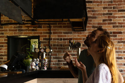 Young couple choosing dishes at bar from menu