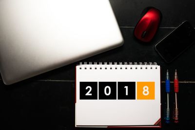 High angle view of calendar with pens and technology on table