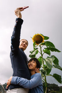 Low angle view of woman standing by plants