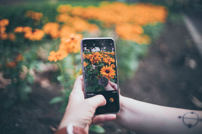 Midsection of person holding smart phone outdoors