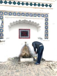 Full length of man on wall against building