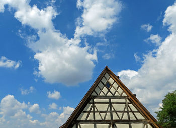 Low angle view of half-timbered house against cloudy sky