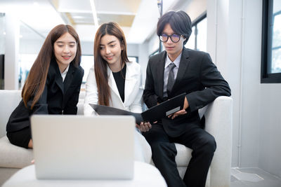 Young woman using mobile phone in laptop