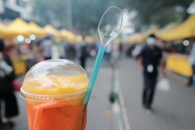 Close-up of mango drink in plastic container