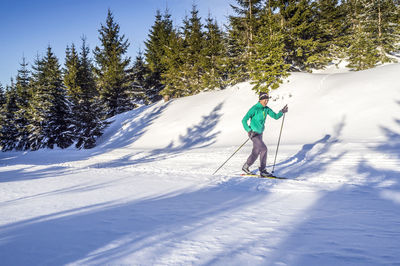 Woman snowboarding during sunny day