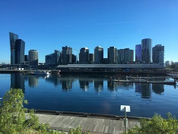 Reflection of buildings in river against blue sky