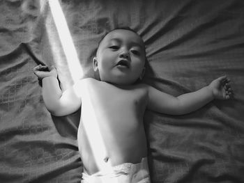 High angle view of baby girl lying on bed at home