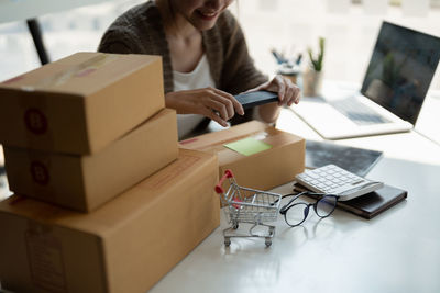 Midsection of woman using laptop on table