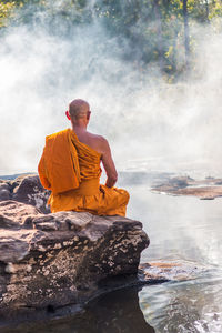 Man meditating on rock