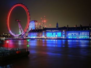 Illuminated ferris wheel in city at night