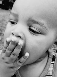 Close-up of cute boy covering mouth with hand