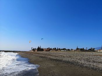 Scenic view of beach against clear blue sky