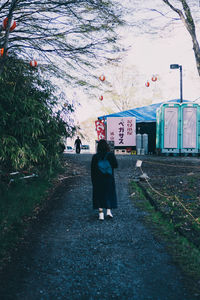 Rear view of people walking on street in city