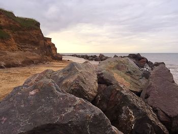 Rock formation in sea against sky