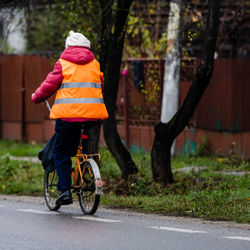 Rear view of man riding bicycle on road