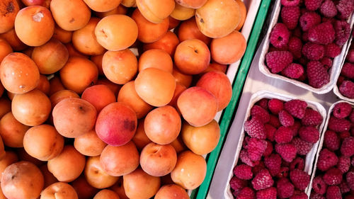 Directly above shot of peaches and raspberries for sale at market stall